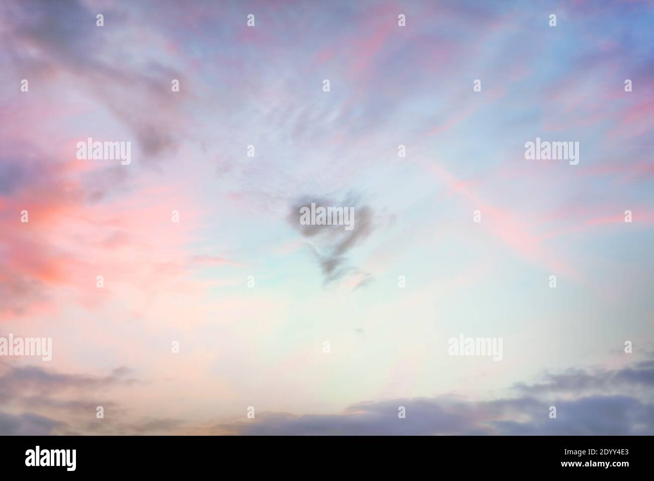 Herzförmige Wolke am Himmel bei Sonnenuntergang. Echte hochauflösende Fotografie Textur Hintergrund. Stockfoto