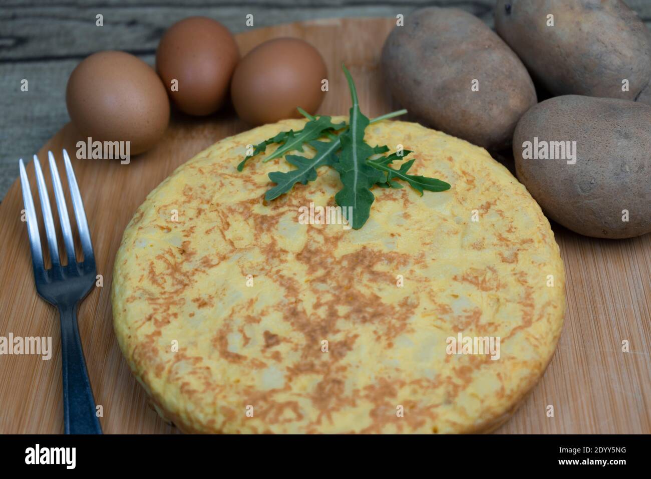 Hausgemachtes spanisches Omelett namens Tortilla de Patatas mit frischen Kartoffeln und Eiern auf Holzbrett.Nahaufnahme klassische spanische Küche Konzept. Stockfoto
