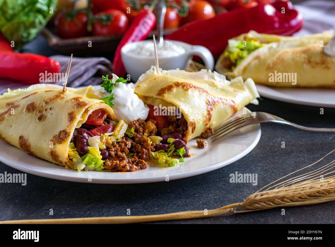 Herzhafte Pfannkuchen mit würzigem Fleisch und Gemüse Füllung auf einem weißen Teller mit Gabel auf Küchentisch. Aufschneiden Stockfoto
