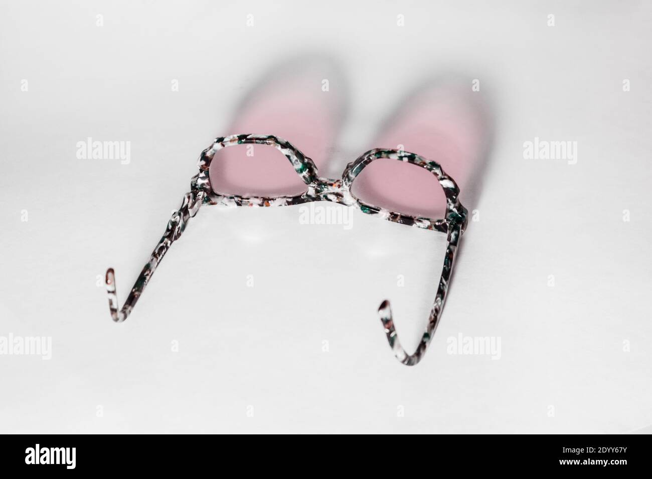 Ein Paar rosafarbene Gläser und ihre Reflexion. Stockfoto
