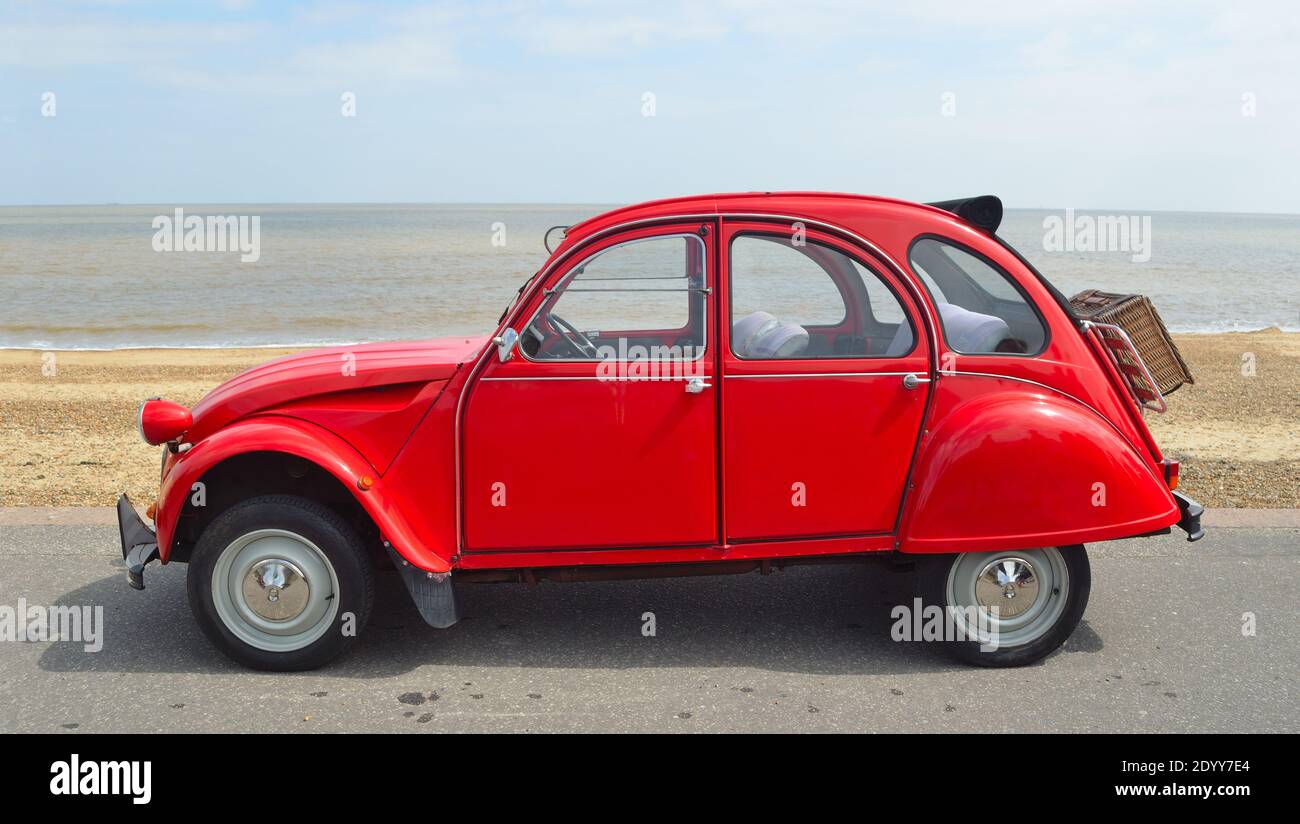 Classic Red Citroen 2CV deux chevaux an der Strandpromenade geparkt. Stockfoto