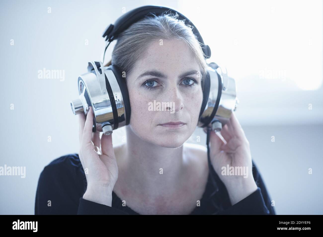 Frau mit einem Satz von Retro-Kopfhörer mit Kabel.Vintage Analog Sound.Frau  hört Musik auf ihren Kopfhörern, weißer Hintergrund Stockfotografie - Alamy
