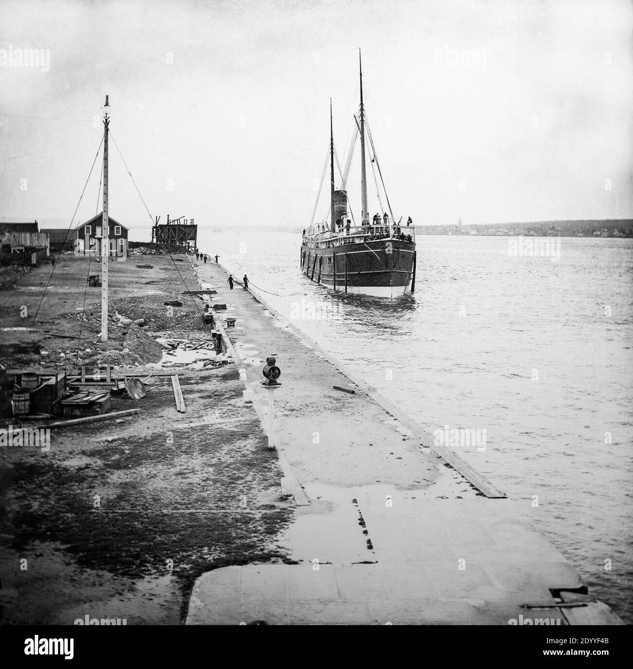 Spätviktorianisches Schwarz-Weiß-Foto, das einen kleinen Dampfliner oder ein Kreuzfahrtschiff zeigt, das sich einem Dock in England nähert. Stockfoto