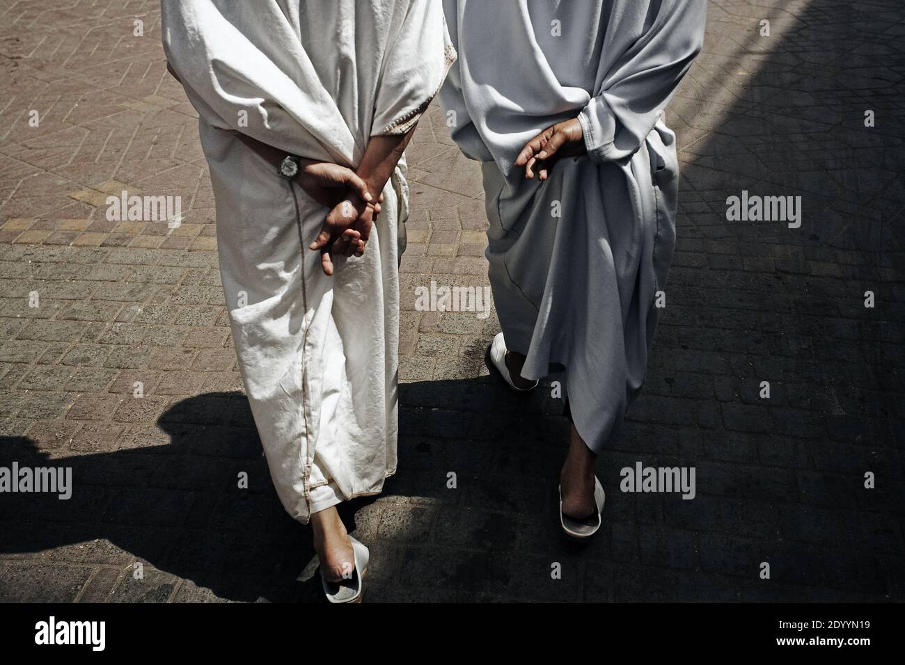 Rückansicht von zwei Mann in traditionellen marokkanischen Djellaba gekleidet zu Fuß auf der Straße von Marrakesch, Marokko. Stockfoto
