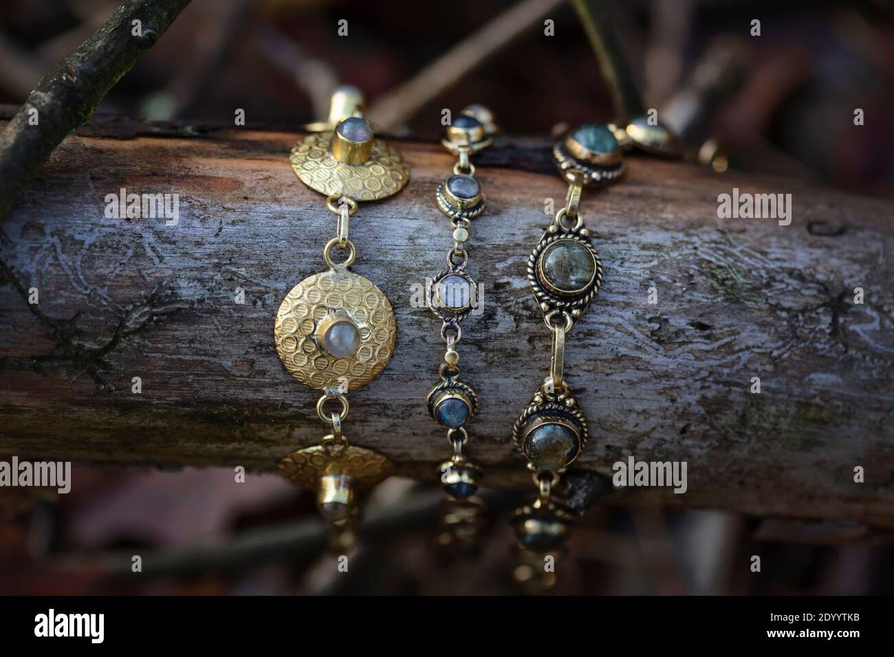 Drei Messingarmbänder mit Labradorit-Stein auf Holzgrund Stockfoto