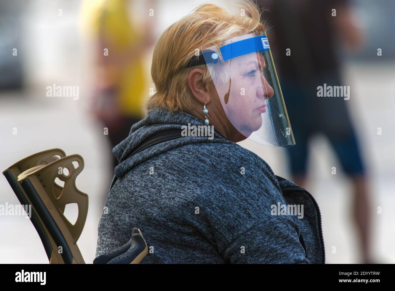 Frau trägt einen Kunststoff-Gesichtsschutz als Schutz vor dem Corona-Virus und anderen luftgetragenen Partikeln und Krankheiten. Stockfoto