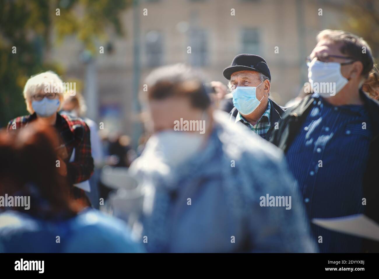 Menschen mit Gesichtsmasken warten in einer Warteschlange auf einen Corona-Virus-Test als Teil einer gemeinsamen Studie. Stockfoto