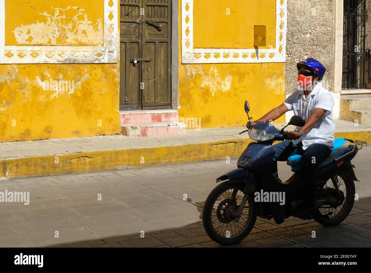 Menschen auf einem Motorrad mit Gesichtsmasken in der Stadt Izamal, Yucatan, Mexiko - während der Covid-19 Pandemie Stockfoto