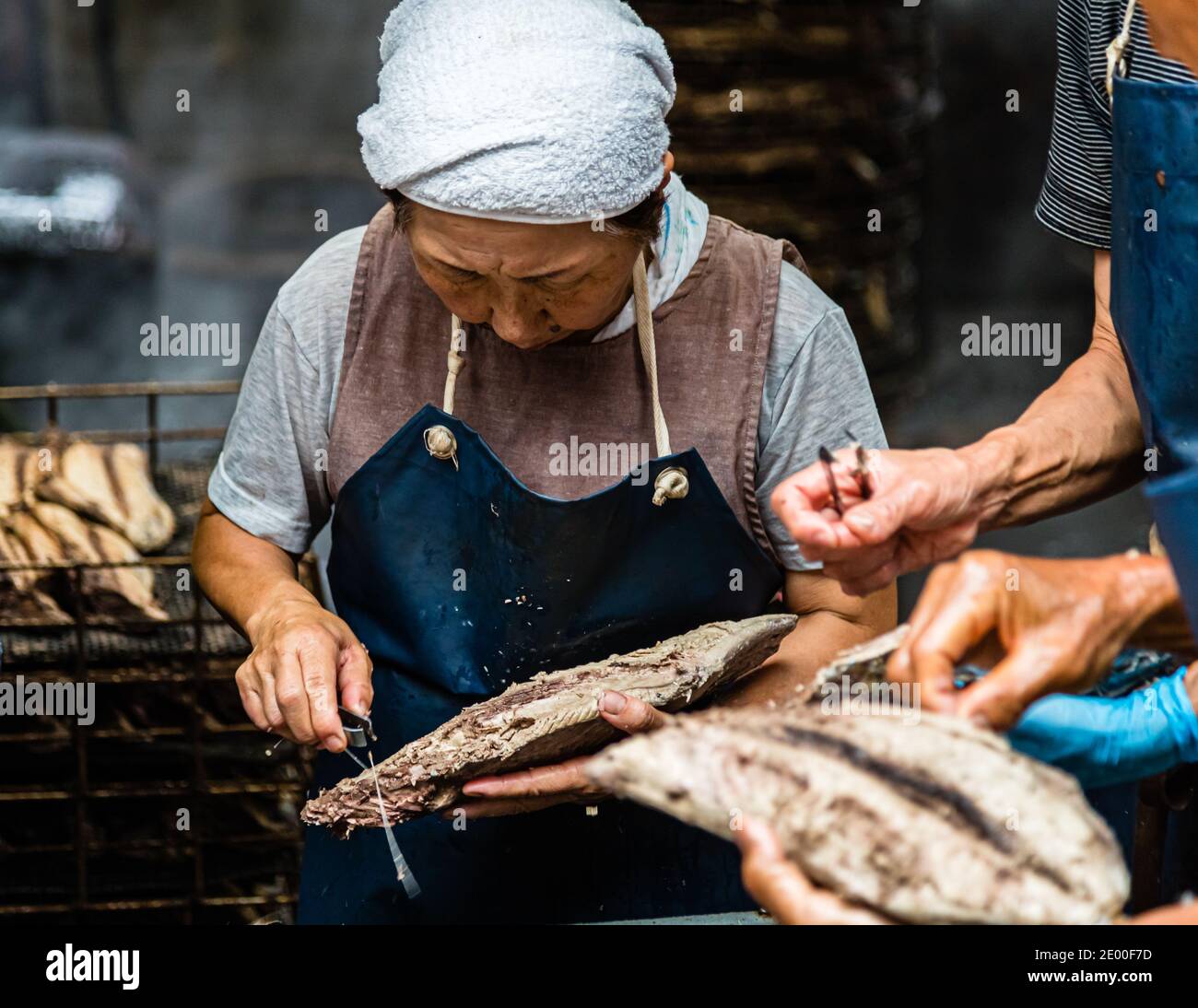 Honenuki ist der Name des manuellen Entgratens der Fischhälften, bei dem der Fisch, der jetzt in vier Filets aufgeteilt ist, so unbeschädigt wie möglich bleiben soll. Yasuhisa Serizawas Katsuobushi-Manufaktur in Nishiizu-Cho, Shizuoka, Japan Stockfoto