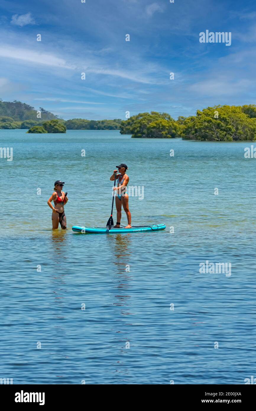 Zwei junge Frauen paddeln im Rainbow Beach, Queensland, QLD, Australien Stockfoto