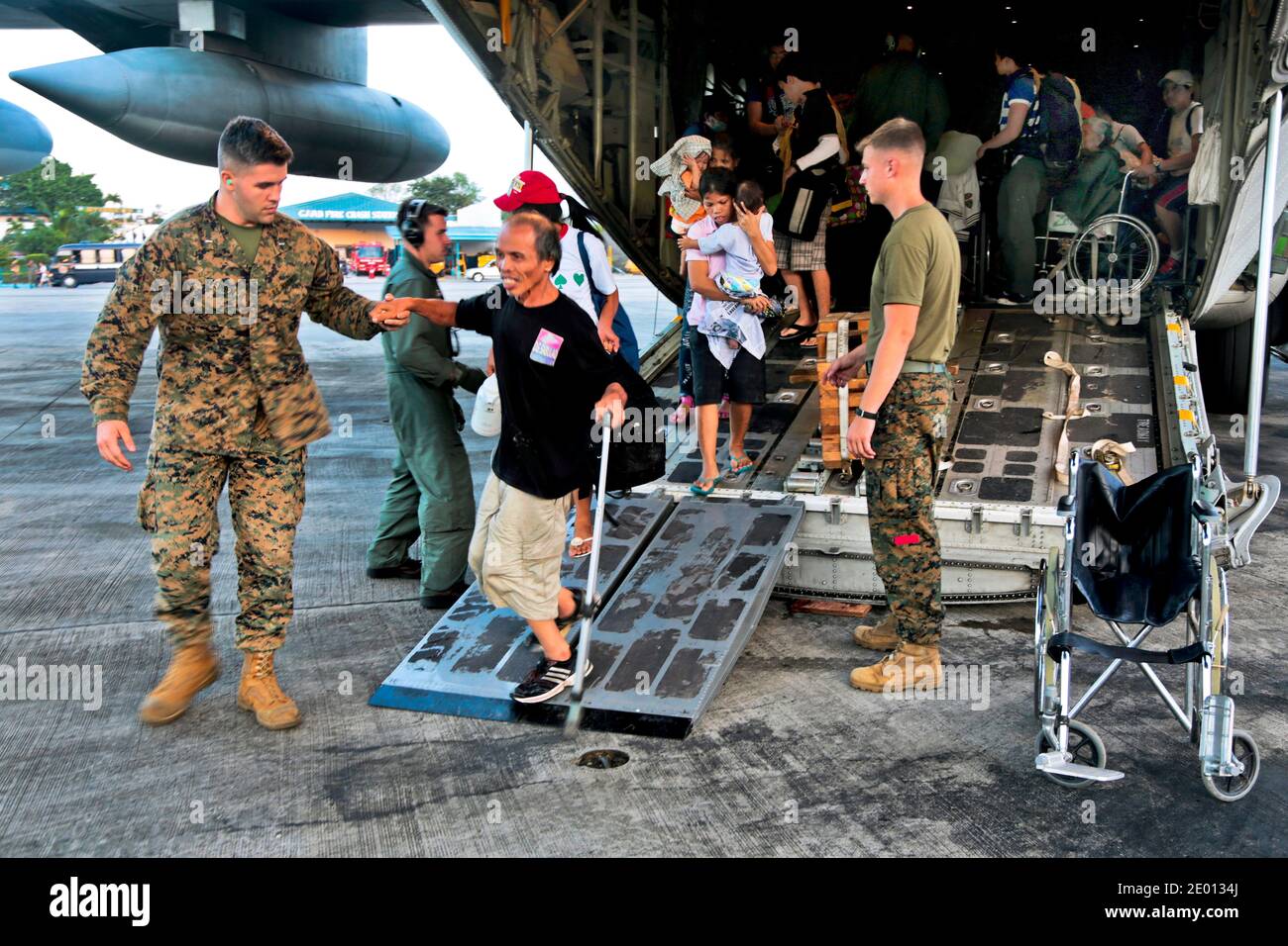 U.S. Marines mit 3d Marine Expeditionary Brigade unterstützen die vom Taifun Haiyan vertriebenen Mitarbeiter von einem KC-130J Super Hercules in Richtung des Terminals der Villamor Air Base, Philippinen, 12. November 2013. Marineinfanteristen und Segler mit 3d MEB unterstützen die philippinischen Streitkräfte bei der humanitären Hilfe und Katastrophenhilfe in den betroffenen Gebieten der Republik Philippinen nach dem Taifun Haiyan. Foto von USMC via ABACAPRESS.COM Stockfoto
