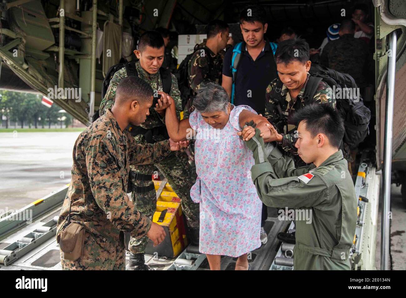 US Marine Lanze CPL. Xavier L. Cannon und Mitglieder der philippinischen Streitkräfte helfen Zivilisten aus einem USMC C-130 Flugzeug auf der Villamor Air Base, Philippinen, 12. November 2013, während humanitärer Hilfsmaßnahmen nach dem Taifun Haiyan. Laut dem National Disaster Risk Reduction and Management Council der philippinischen Regierung hat der Sturm mehr als 4.2 Millionen Menschen in 36 Provinzen auf den Philippinen getroffen. Die Marines sind mit der 3. Marine Expeditionary Brigade, III Marine Expeditionary Force. Foto von USMC via ABACAPRESS.COM Stockfoto