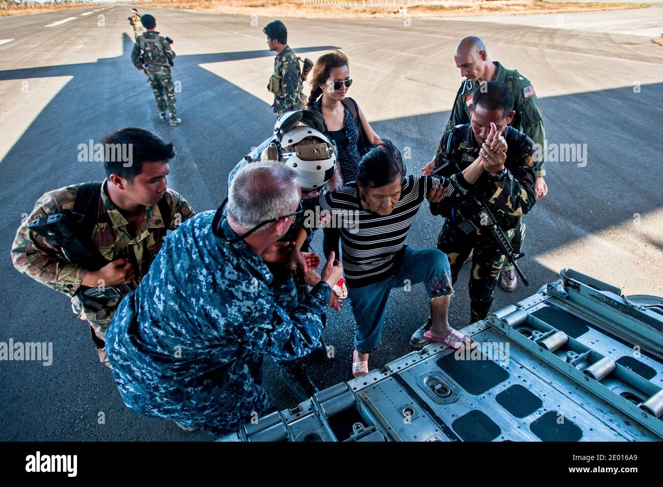 Matrosen und Soldaten der philippinischen Armee helfen einer Frau auf einen HC-130 Hercules vom Marine Wing Support Squadron (MWSS) 172, an einen sichereren Ort gebracht zu werden. Die George Washington Carrier Strike Group unterstützt die 3. Marine Expeditionary Brigade, um die philippinische Regierung bei der Operation Damayan als Reaktion auf die Folgen des Super-Taifuns Haiyan/Yolanda in der Republik Philippinen zu unterstützen. Foto von US Navy via ABACAPRESS.COM Stockfoto