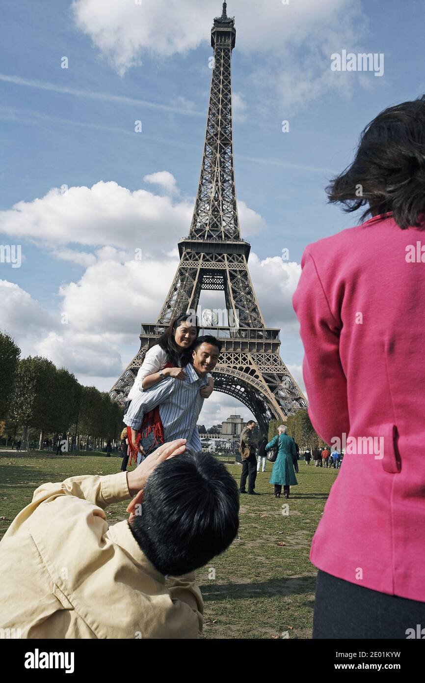 FRANKREICH / Ile de France / Paris / Eiffelturm mit chinesischen Touristen, die Fotos machen Stockfoto