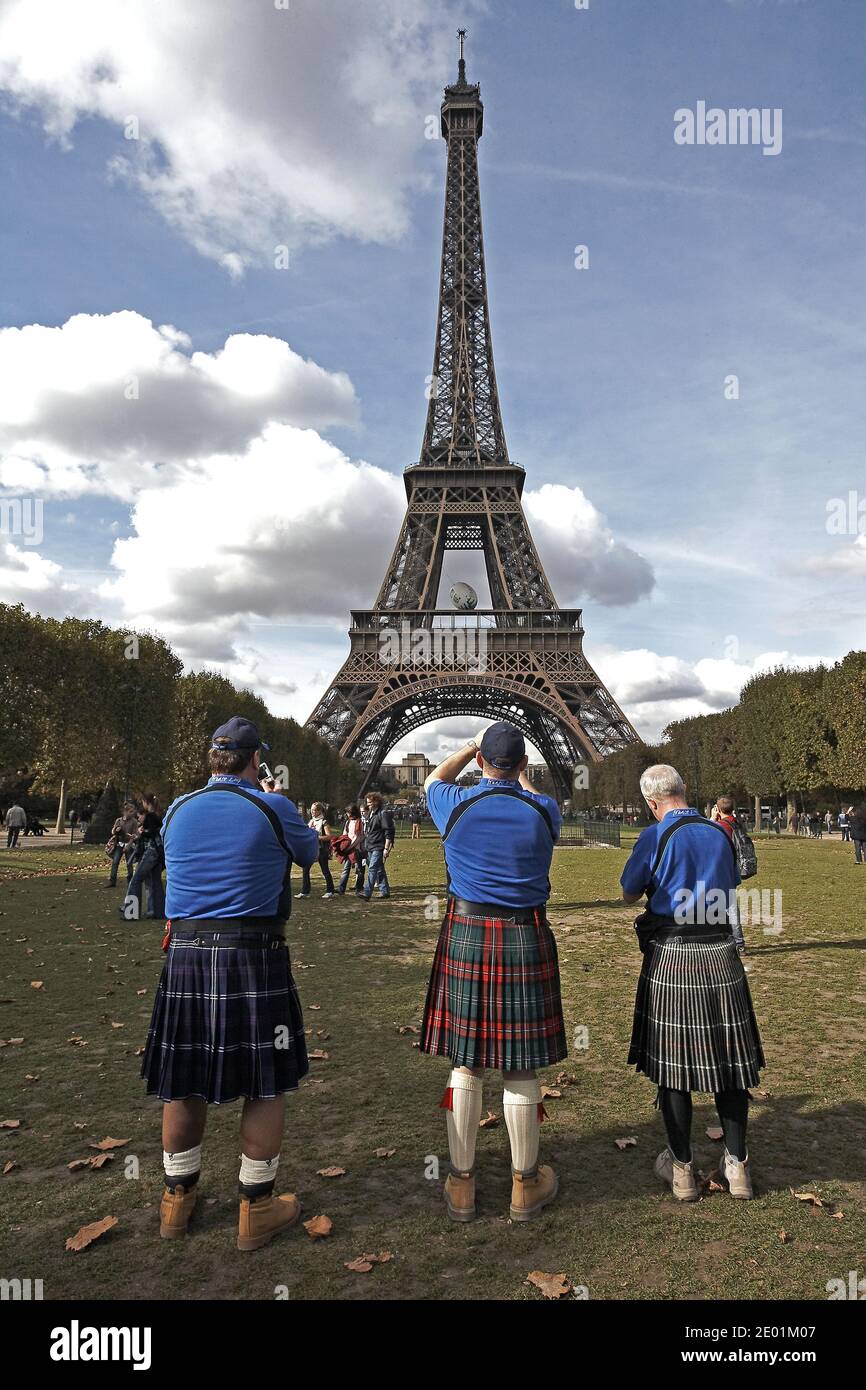 FRANKREICH / Ile de France / Paris /Eiffelturm mit schottischen Touristen in Kilts, die Fotos machen. Stockfoto