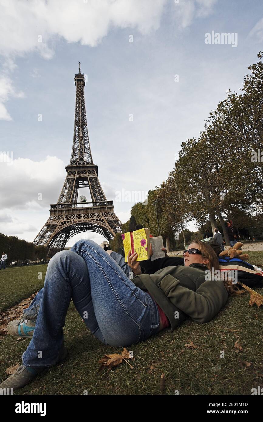 FRANKREICH / Iie-de-France/Paris/ junger Peopel beim Lesen auf dem Rasen mit dem Eiffelturm in der Ferne. Stockfoto