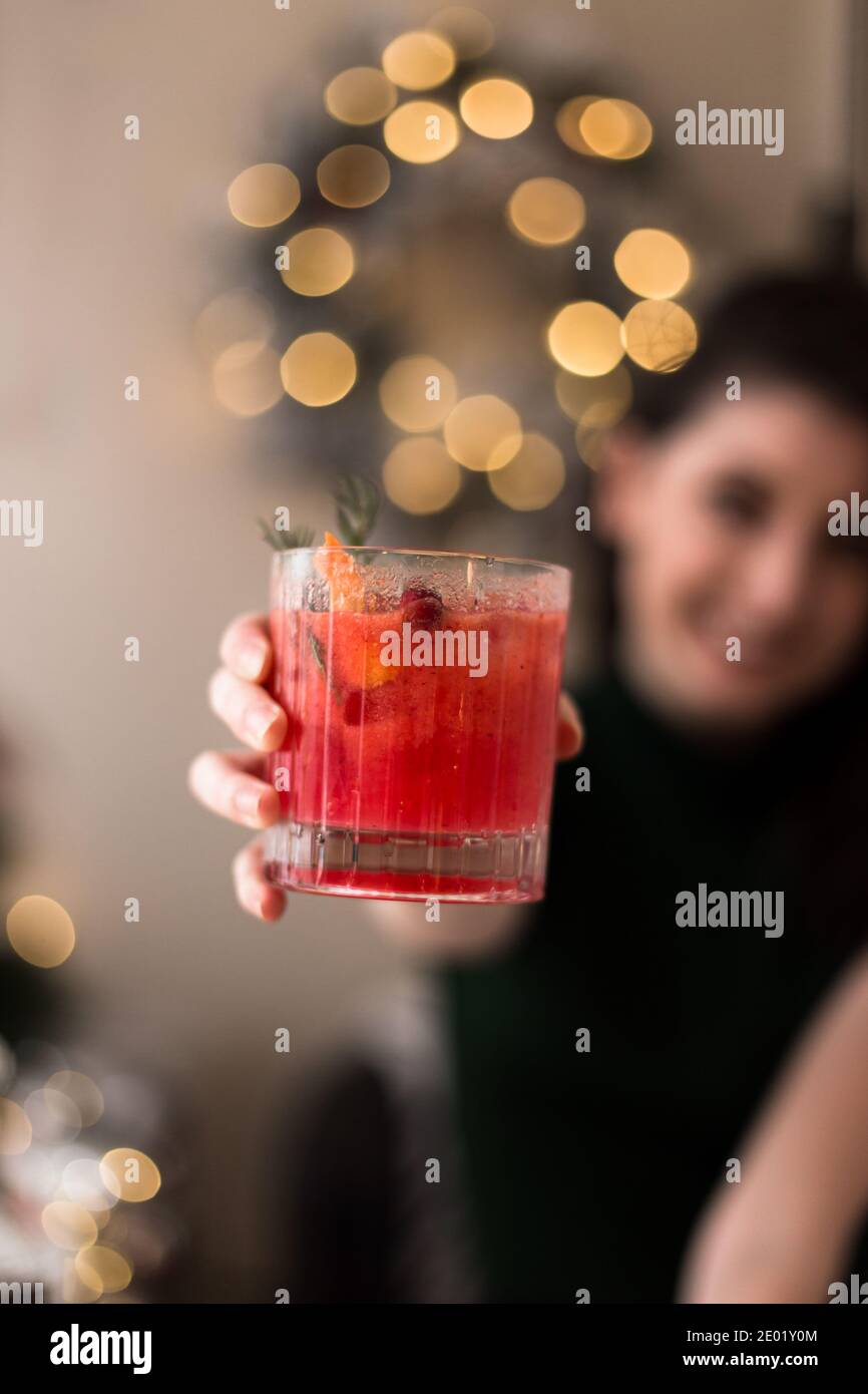 Hübsche junge Frau hält einen köstlichen Cranberry Cocktail zu Weihnachten. Stockfoto