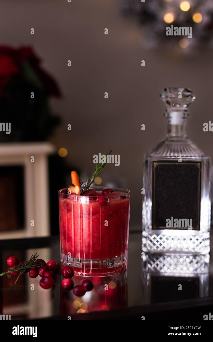 Cranberry-Cocktail mit Weihnachtsmotiven und einer Flasche. Stockfoto