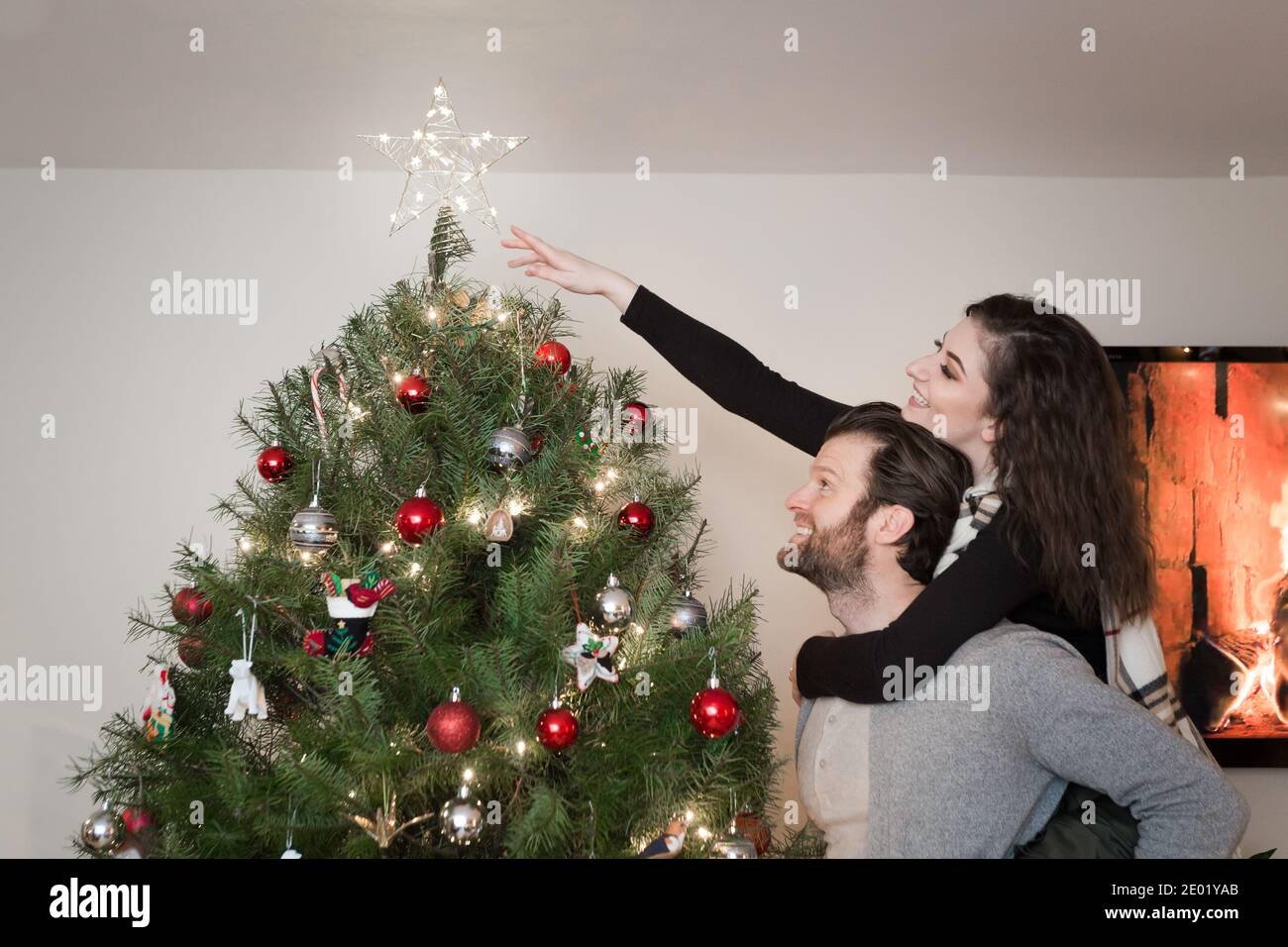 Junge glücklich paar Zeitraffer Dekoration Weihnachtsbaum. Stockfoto