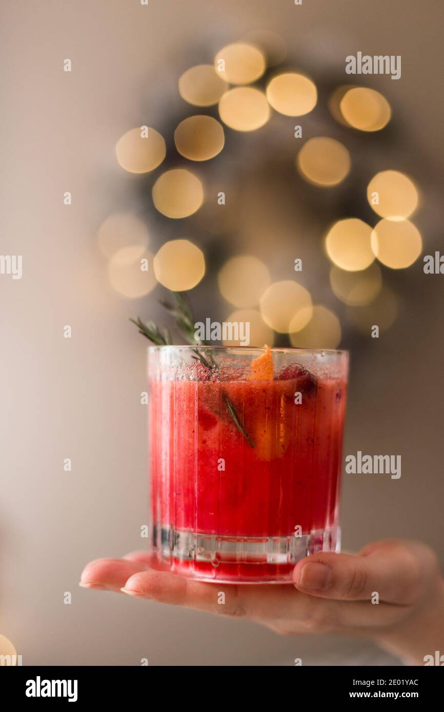Eine Frau hält einen Weihnachts-Cranberry-Cocktail in der Hand. Stockfoto