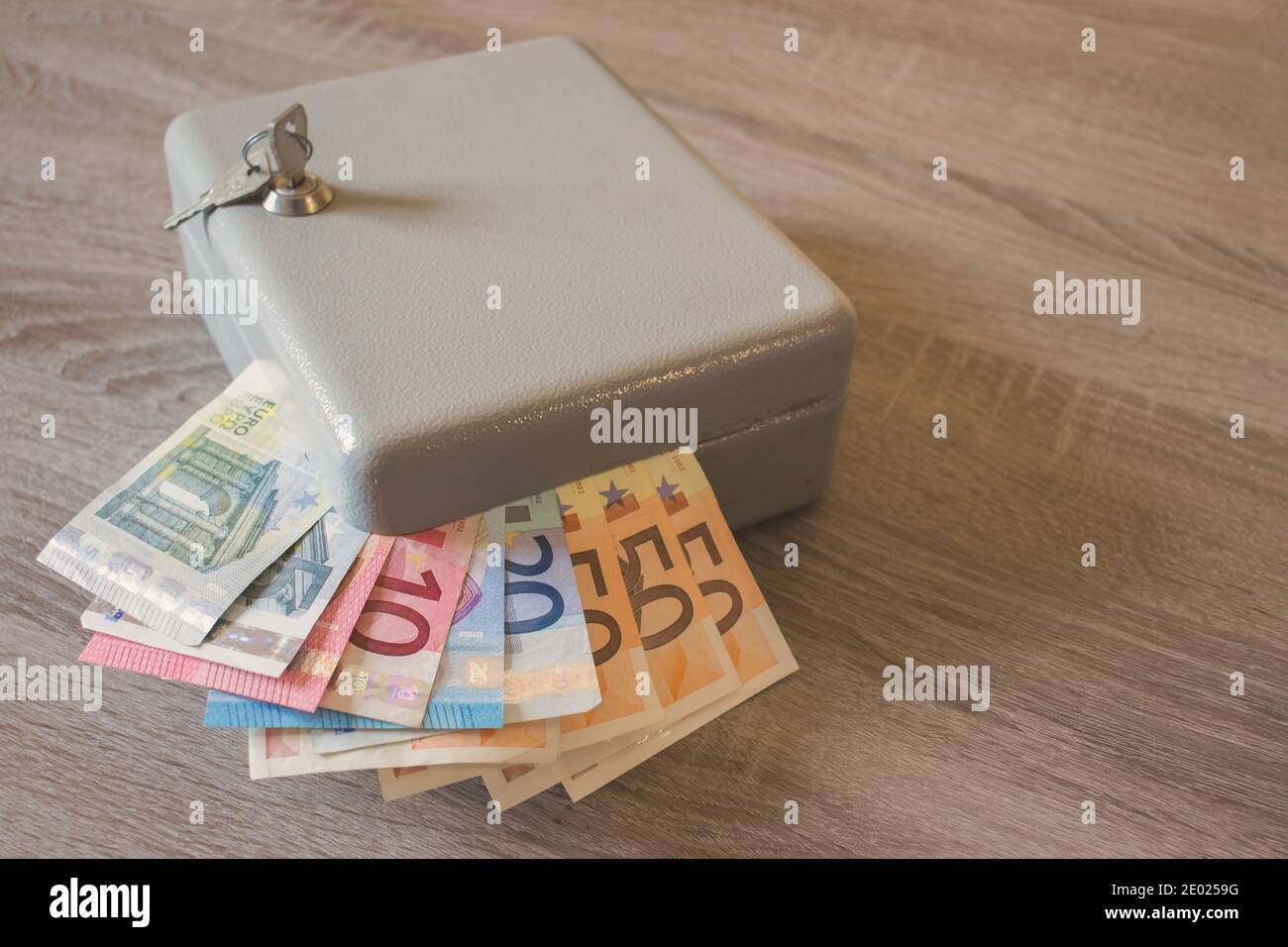 Mini Vault Silber Safes mit Haufen von Tickets in Euro Auf einem Holztisch Stockfoto