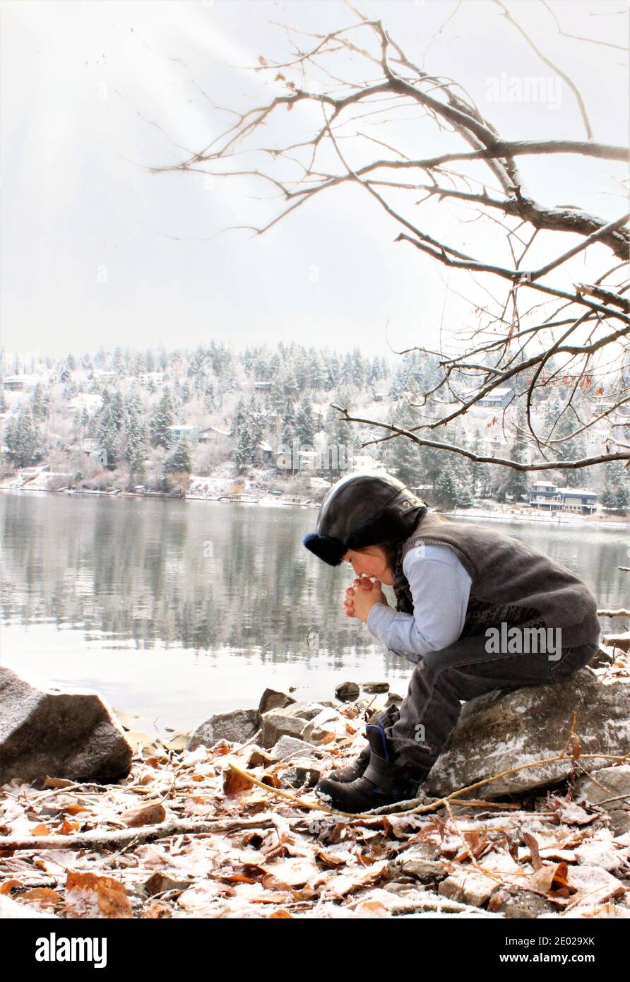 Kind Betet Winter See Stockfoto