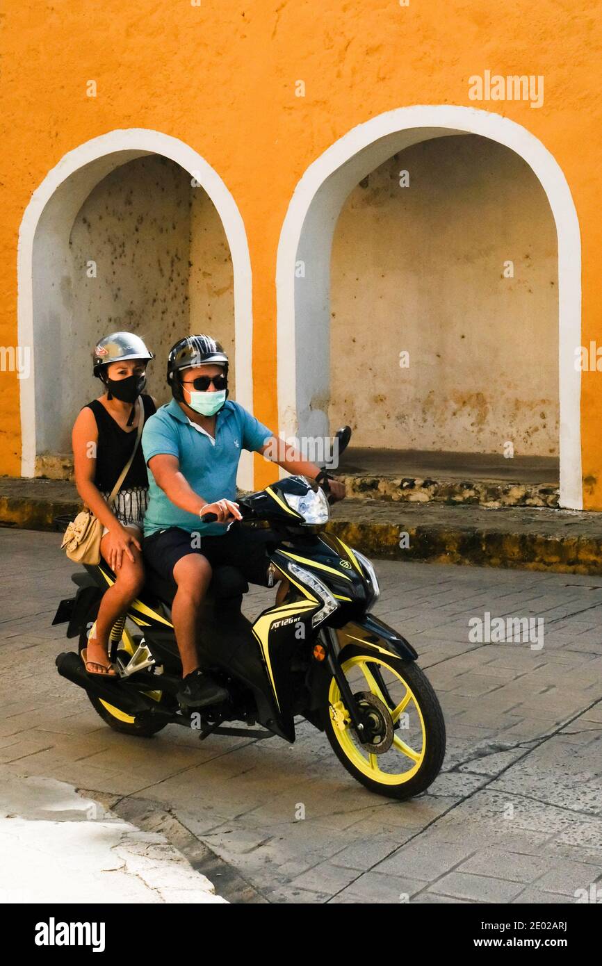 Menschen mit Gesichtsbezügen auf einem Motorrad während der Covid-19 Pandemie, Yucatan, Mexiko Stockfoto