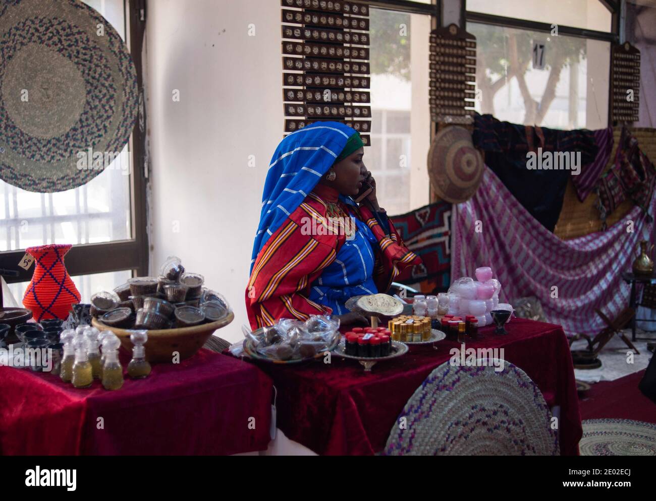 Tripolis. Dezember 2020. Eine Libyerin in traditioneller Tracht telefoniert am 28. Dezember 2020 auf der Tripoli International Fair in Tripoli, Libyen. Kulturelle Aktivitäten wie Buchmesse, Kunstmesse, Fotomesse und traditionelle Messe sind für die Öffentlichkeit kostenlos und dauern bis zum 30. Dezember. Quelle: Nada Harib/Xinhua/Alamy Live News Stockfoto