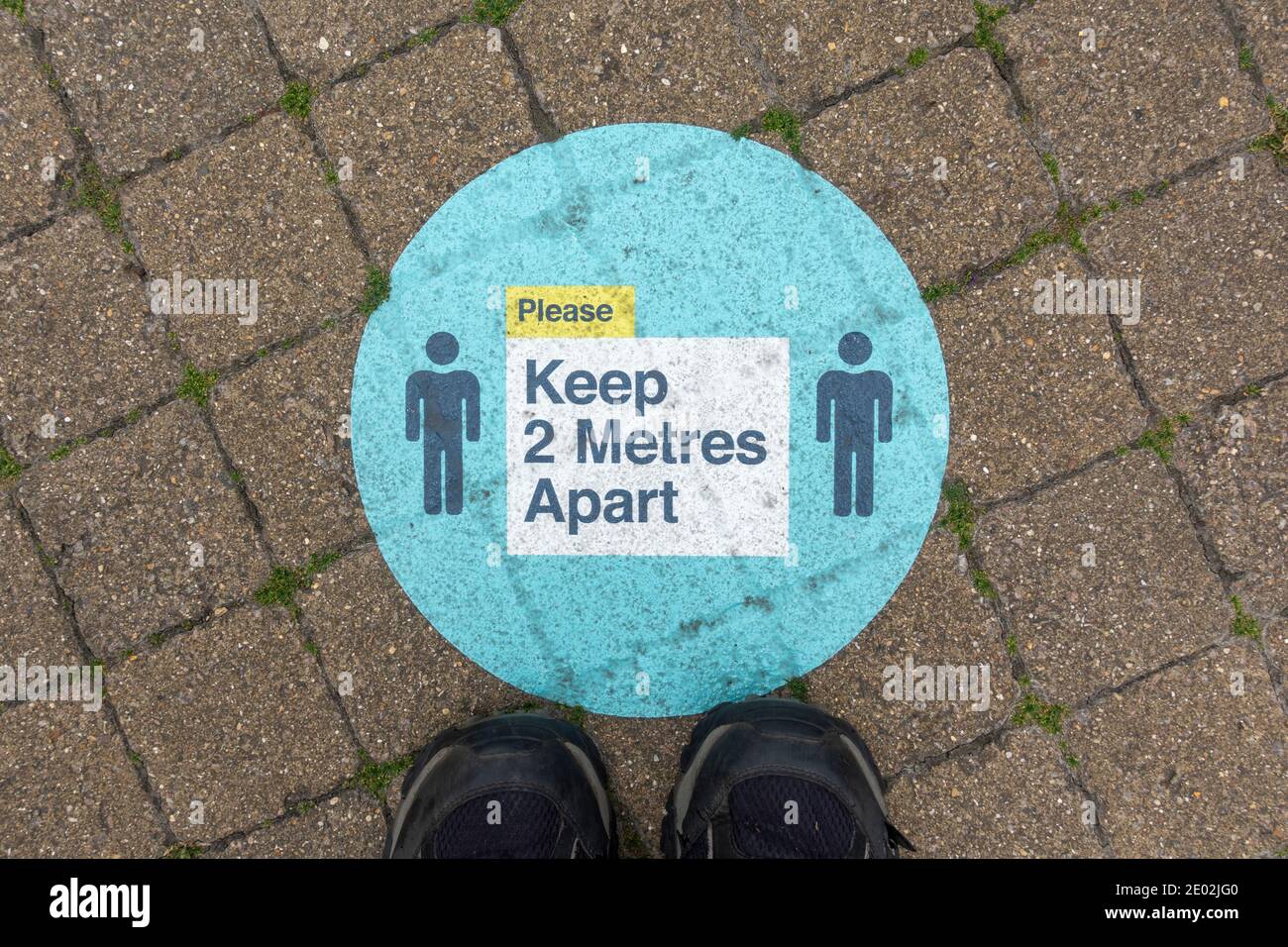 "Halten Sie 2 Meter auseinander" Zeichen auf dem Boden erinnert die Menschen an soziale Distanz während der 2020 Covid-19 Pandemie, Windsor, Berkshire, Großbritannien. Stockfoto