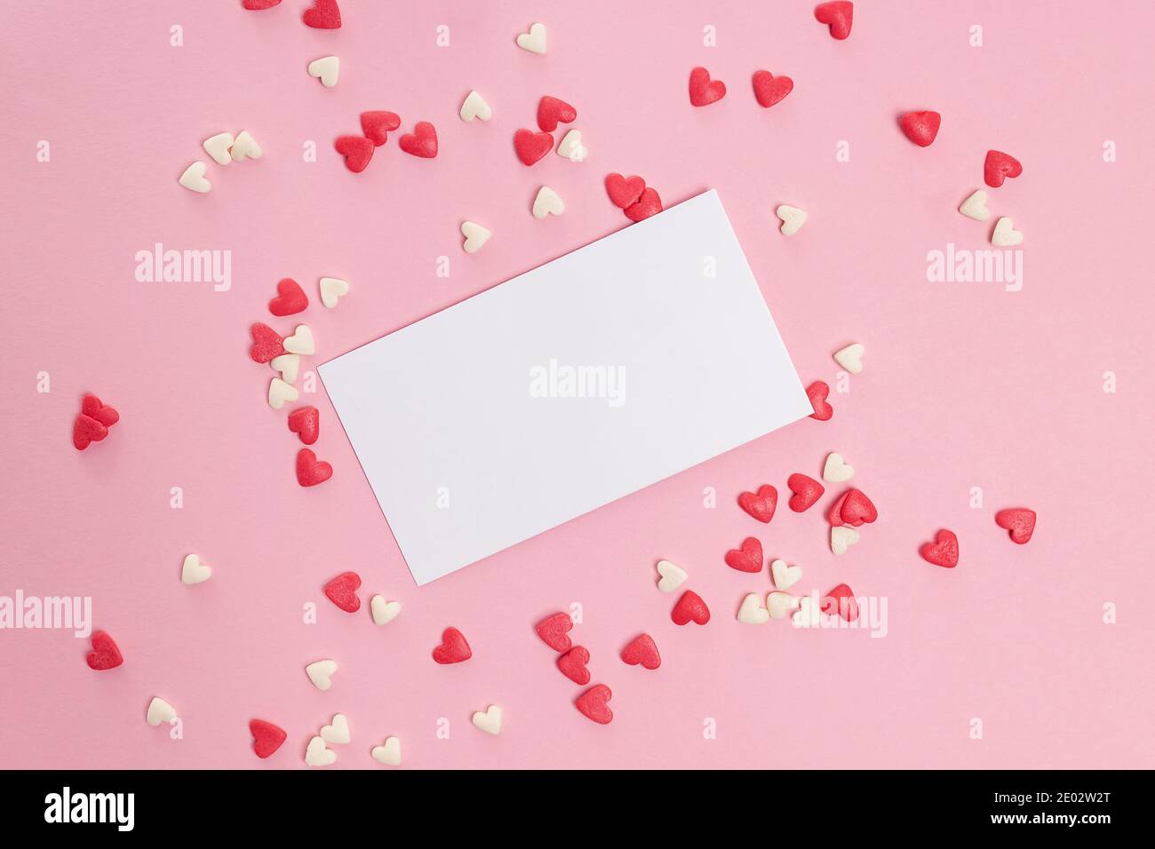Leere Papierkarte und kleiner herzförmiger Zucker streuen Stockfoto