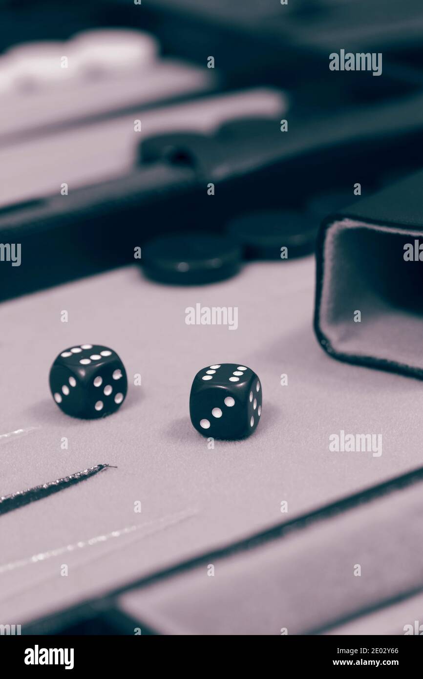 Backgammon-Set, bereit, Spiel zu starten, auf einem Tuch und Lederbrett. Mit Farbtonung Stockfoto