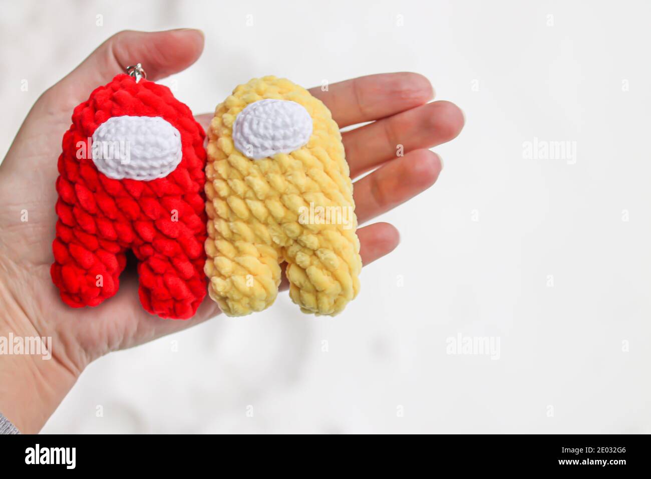 Häkelspielzeug Crew Mitglied unter uns rot und gelb Impostor Stockfoto