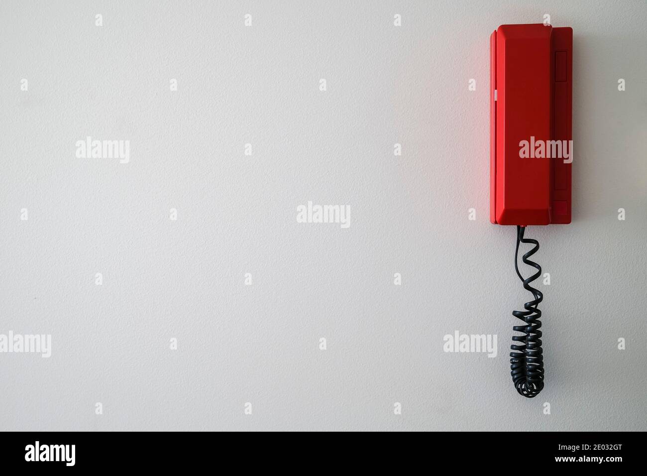 Rotes Notruftelefon an weißer Wand Stockfoto