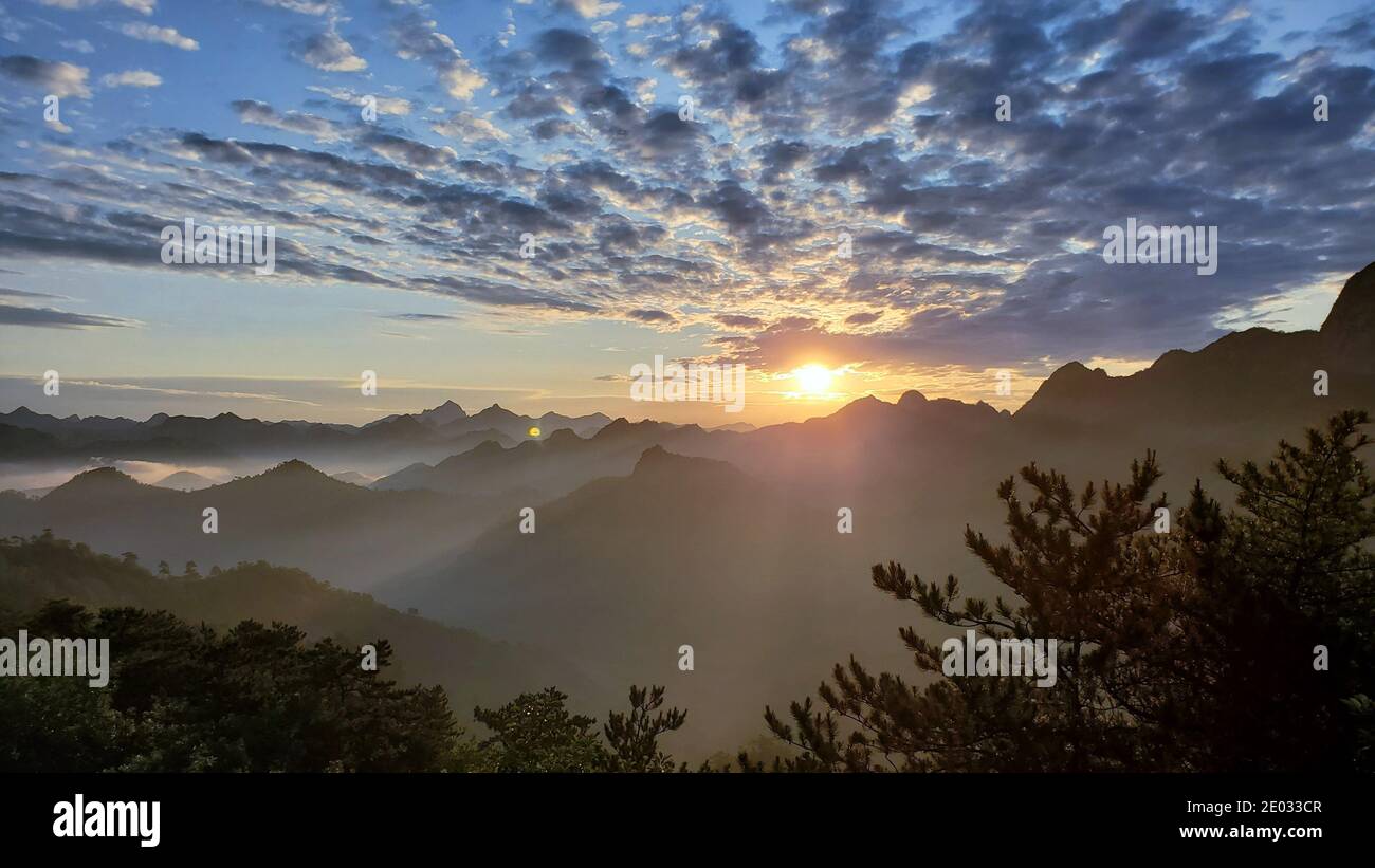 Schöne Aussicht auf Sonnenaufgang am frühen Morgen, Silhouette der schwebenden Wolken und Berge Stockfoto