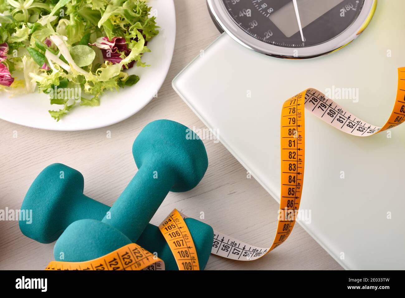 Gesunde Lebensweise Hintergrund mit Hantel-Salat und Gewichtskontrolle oben. Draufsicht. Horizontale Zusammensetzung. Stockfoto