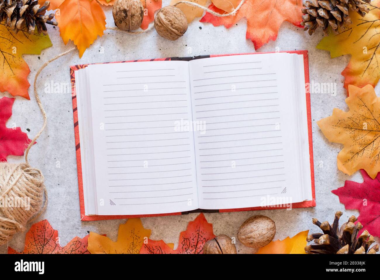 Notizbuch mit sauberen Laken auf grauem Hintergrund mit hellen Herbstblättern. Herbststimmung Konzept. Flach liegend, Draufsicht, Kopierbereich Stockfoto