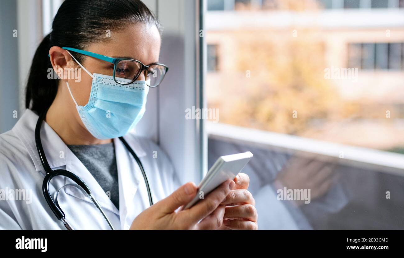 Ärztin chattet am Telefon Stockfoto