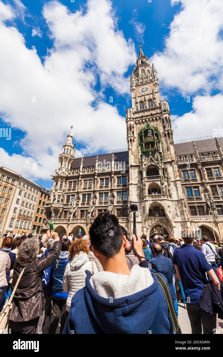 Touristen fotografieren das Glockenspiel des Neuen Rathauses in München Stockfoto