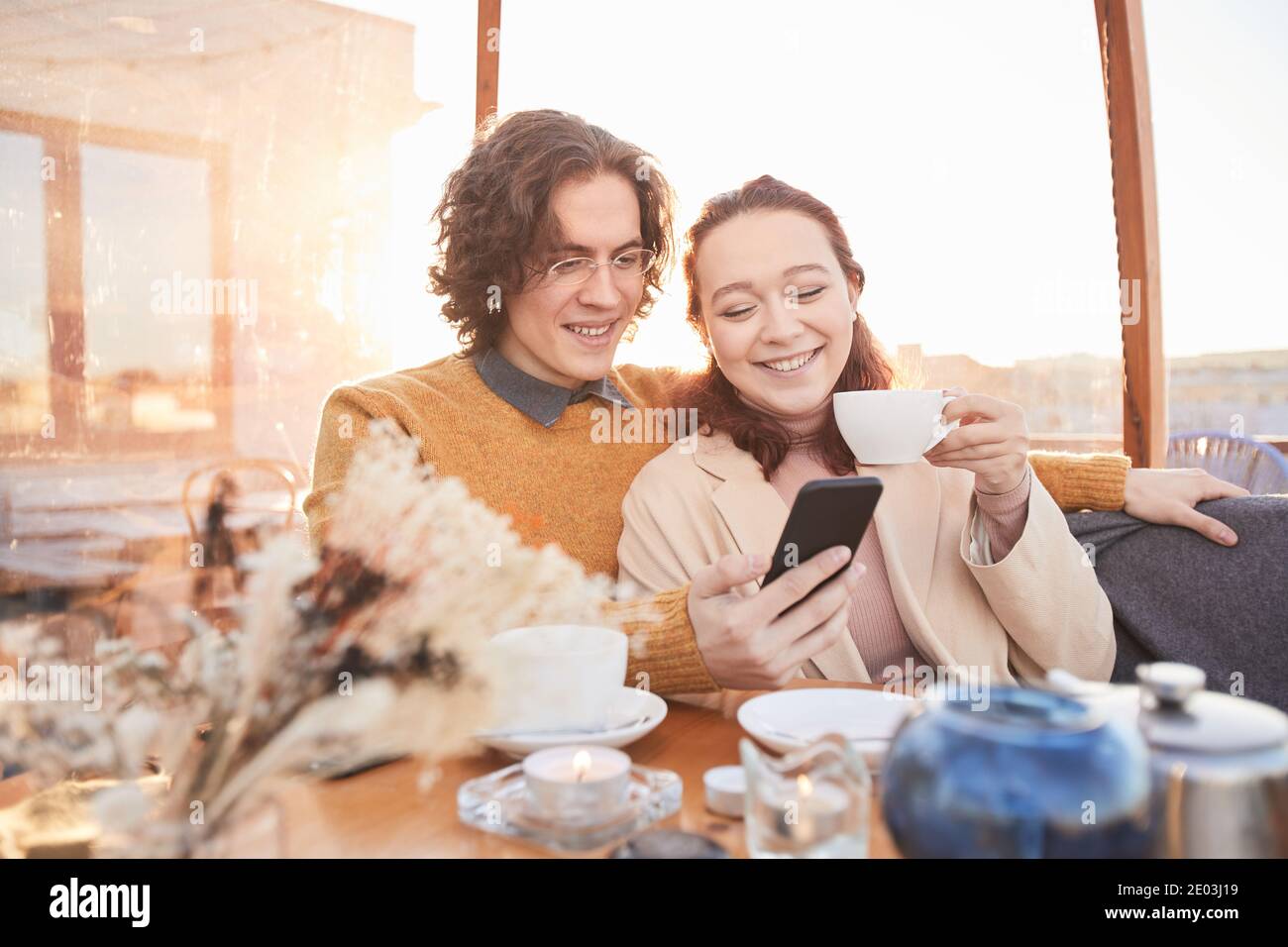 Glückliches junges Paar verbringt Zeit zusammen, Fotos auf Handy zu sehen Telefonieren und sich an glückliche Momente erinnern Stockfoto