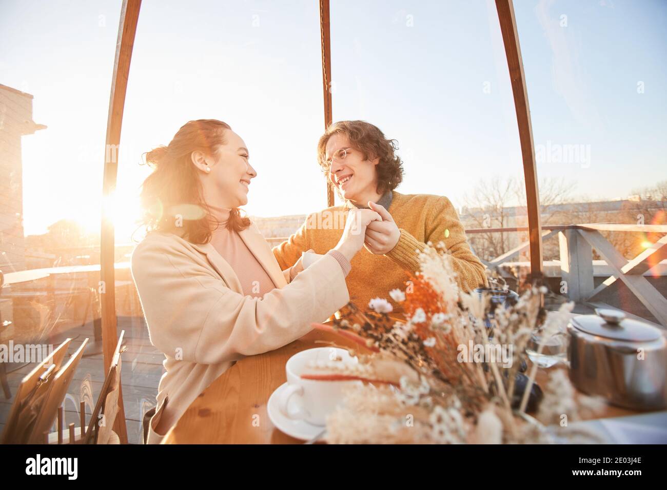 Glückliches Paar, das Hände hält und sich lächelt Ein Date an einem schönen Ort im Restaurant Stockfoto