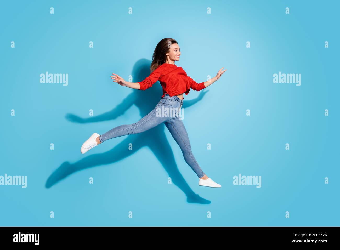 In voller Länge Foto von Dame springen hoch bewegen wie Ballerina Anmutiger Bewegungsschatten isolierter blauer Hintergrund Stockfoto