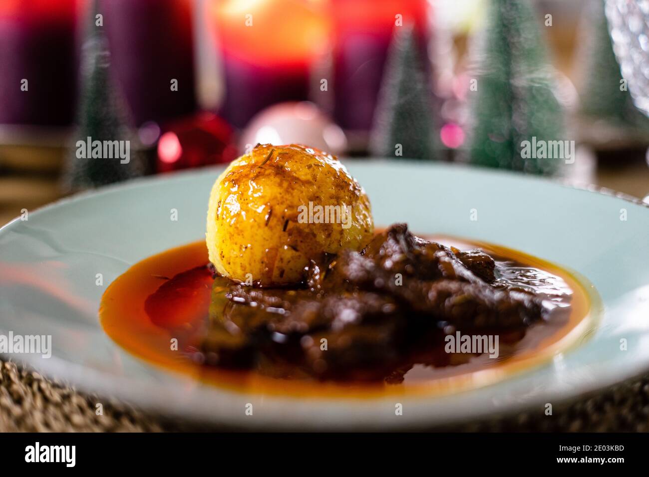 Köstliches weihnachtsessen mit Knödel und weihnachtsdekoration im Hintergrund Stockfoto