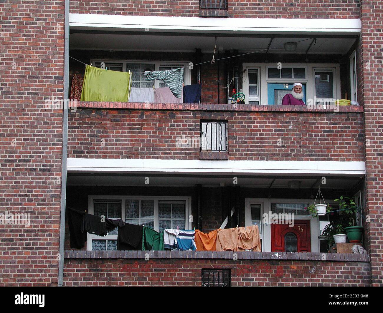 Mann auf dem Balkon von Shadwell rat sozialen Wohnimmobilien in Tower Hamlets Docklands London Großbritannien Stockfoto Mann auf dem Balkon von Shadwell rat sozialen Wohnimmobilien in Tower Hamlets Docklands London Großbritannien Stockfoto