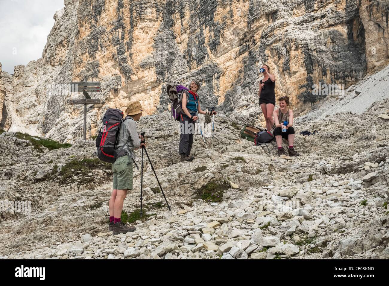 Vier Wanderfrauen halten für eine Pause in den Dolomiten, Norditalien, auf dem Alta Via 1 Fernwanderweg Stockfoto