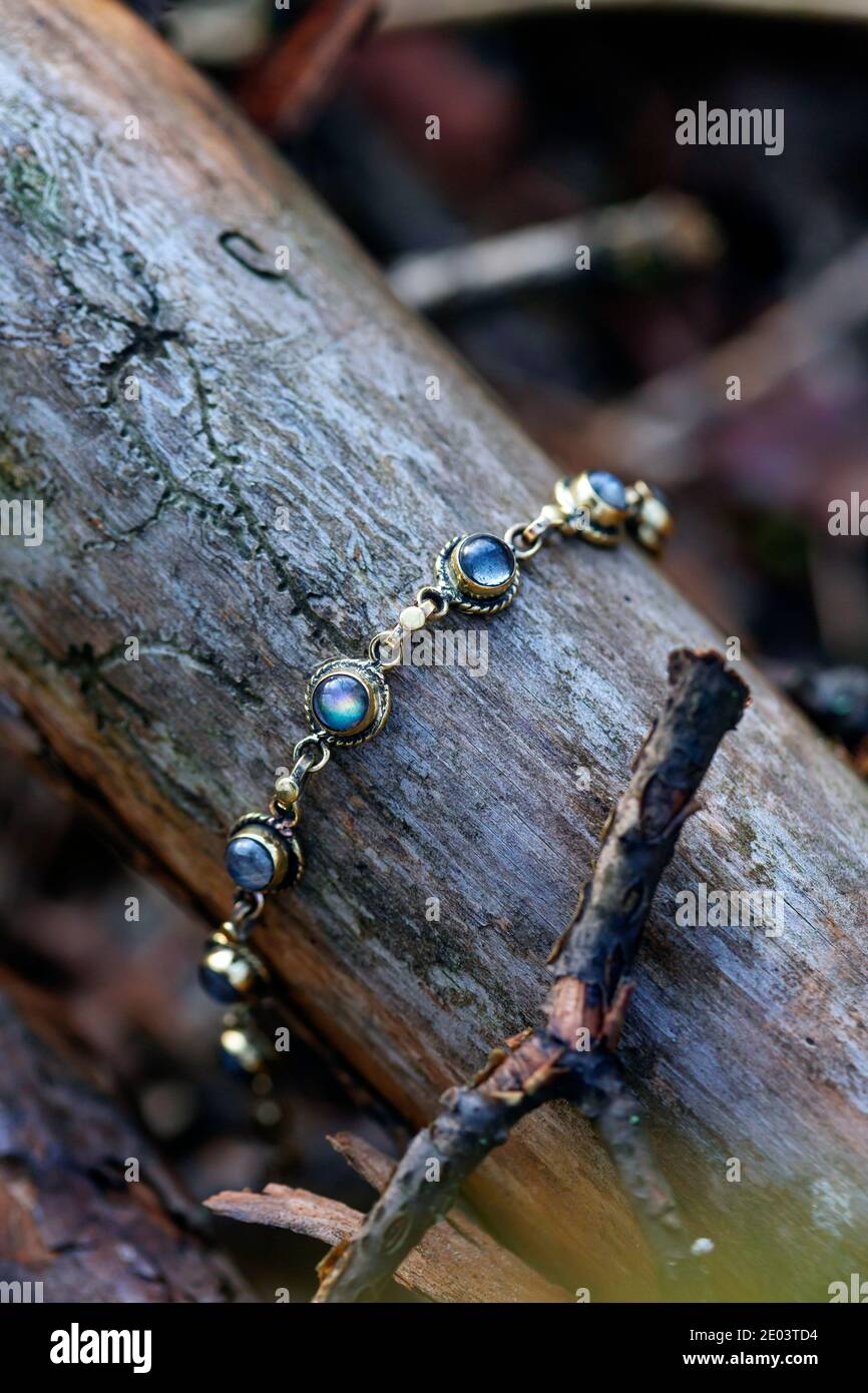 Armband aus Messing mit Labradorit-Stein auf Holzgrund Stockfoto