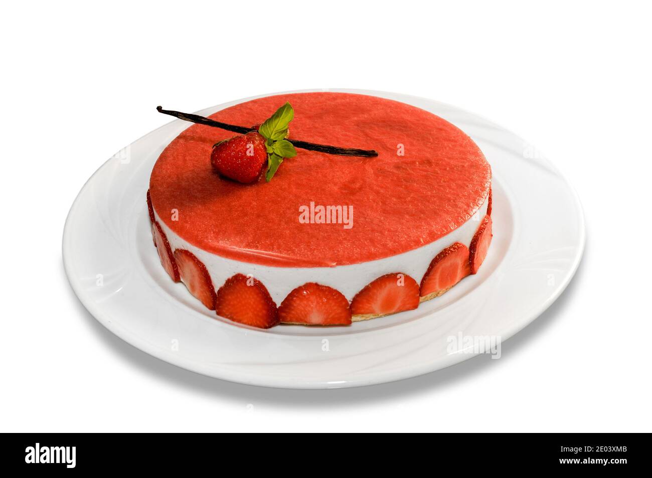 Käsekuchen mit Erdbeeren, ganze Torte mit roter Erdbeercreme mit Vanilleschote und Minzblättern in Teller isoliert auf weißem Hintergrund bedeckt Stockfoto