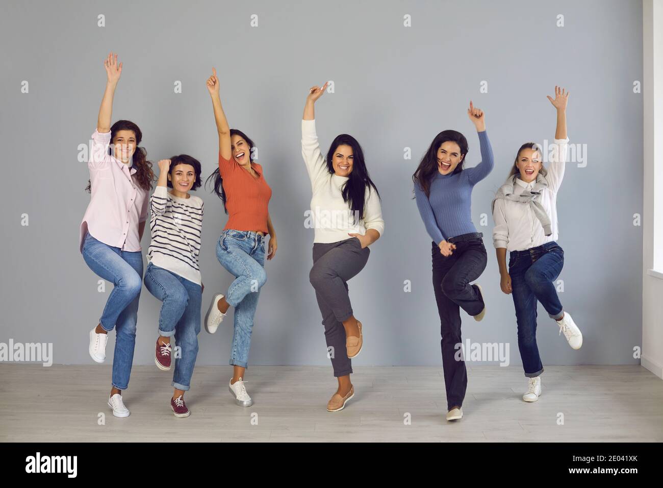 Gruppe von glücklichen jungen Frauen springen vor Freude und Lachen, feiern Teamerfolg Stockfoto