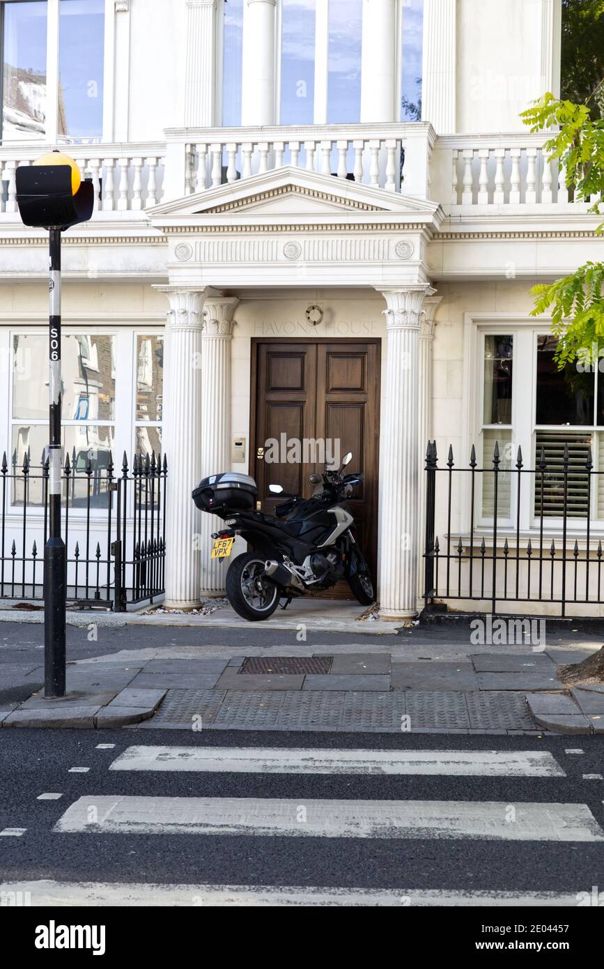 Motorrad vor einer Tür in der Nähe von a geparkt zebra Kreuzung in Notting Hill London Stockfoto