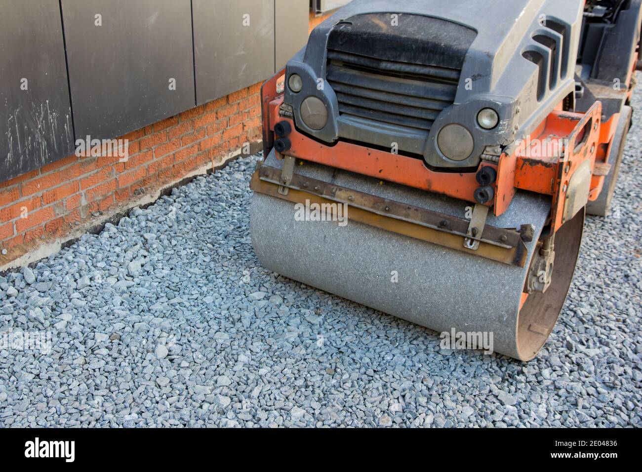 Entwicklung der städtischen Infrastruktur. Straßenbaustufe. Asphalt Straßenwalze mit schweren Vibrationswalze Walzenpresse Granit Schotter. Neu Stockfoto