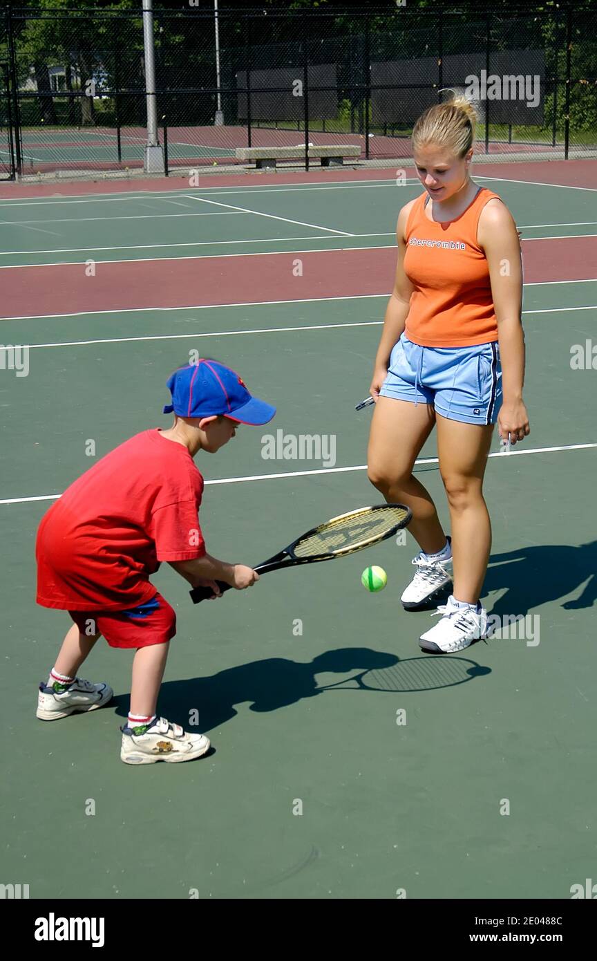 Der vierjährige Junge lernt, einen Tennisball zu hüpfen Während des Unterrichts in einer Jugendtennisklinik Stockfoto